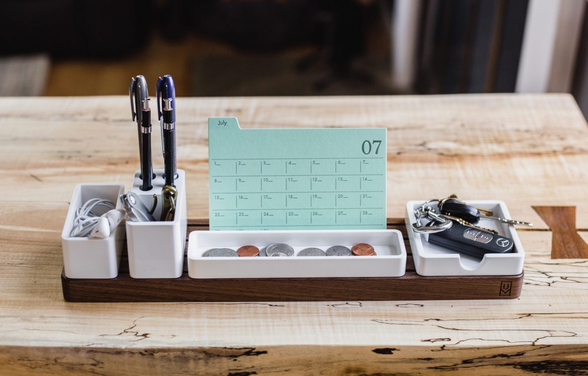 UK Financial Regulators: A desk 'tidy' (organiser) containing two pens, several coins, a calendar (no appointments booked) earphones and a set of keys