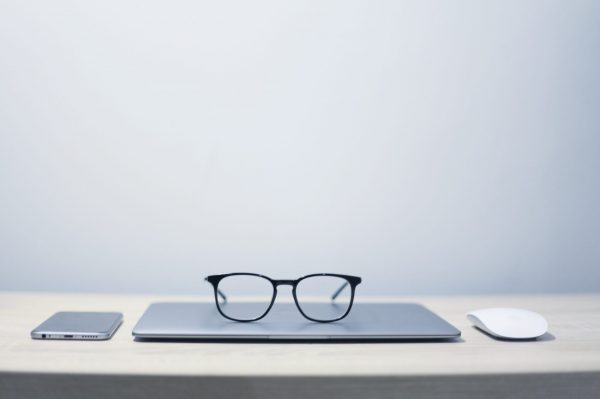 Financial crime : Photo shows a number of objects sitting on a desk. A phone, reading glasses, mouse and mouse mat