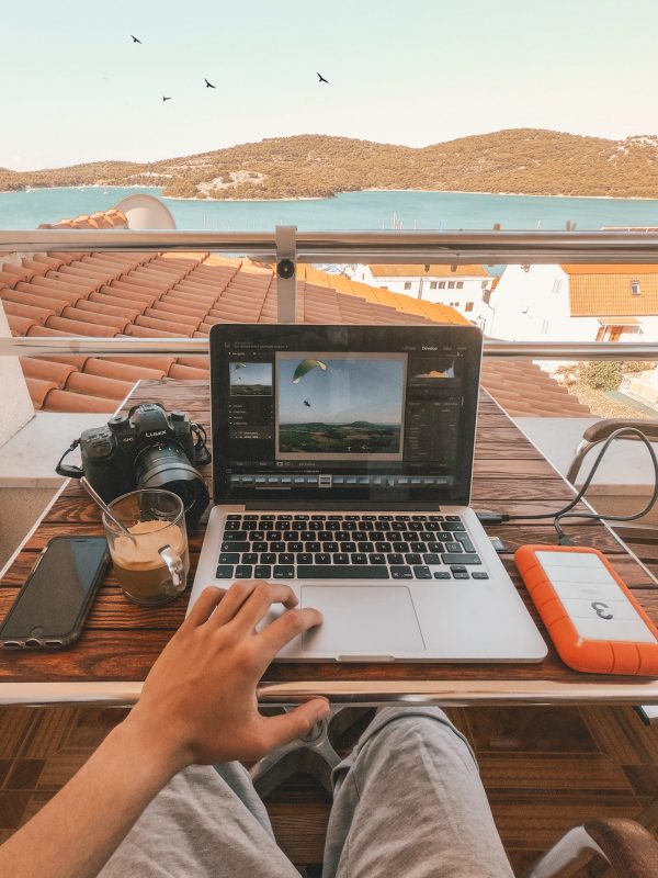 Equity financing: Person working at a laptop with view from balcony across a bay.