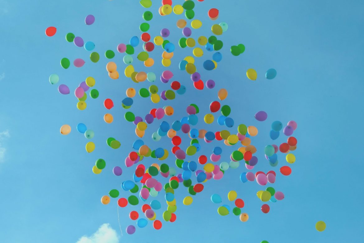 Choosing a financial adviser: Over 100 balloons in different colours being released against a clear blue sky