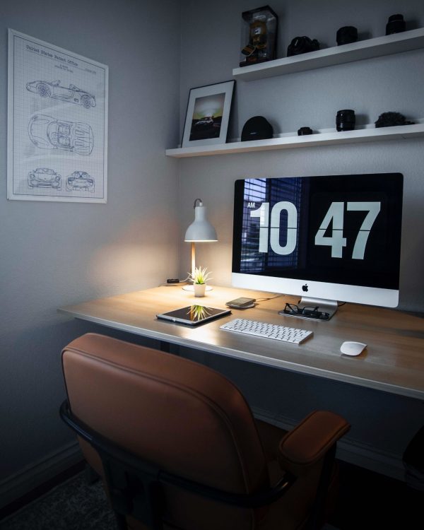 What is corporate finance? Home office, corner desk with lamp and laptop. shelving with ornaments
