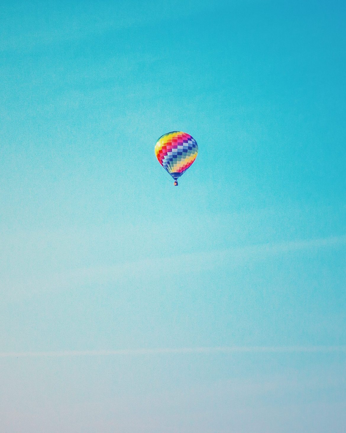 Examples of crowdfunding: Multi-coloured hot air balloon sailing along against a clear blue sky