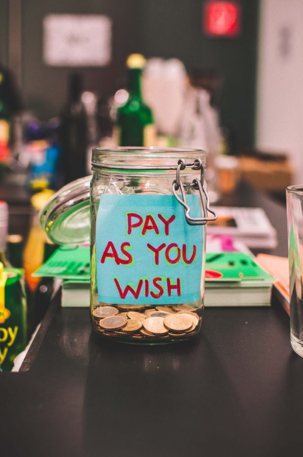Pension Apps: Money jar on a table with a post-it note attached