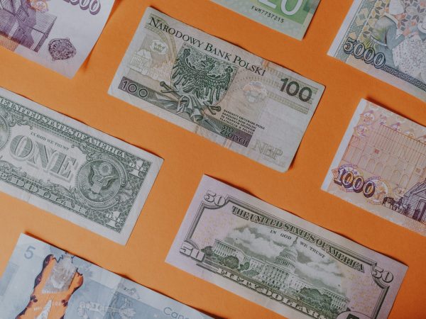 Collecting banknotes: A series of banknotes from different countries placed on a flat surface with an orange background