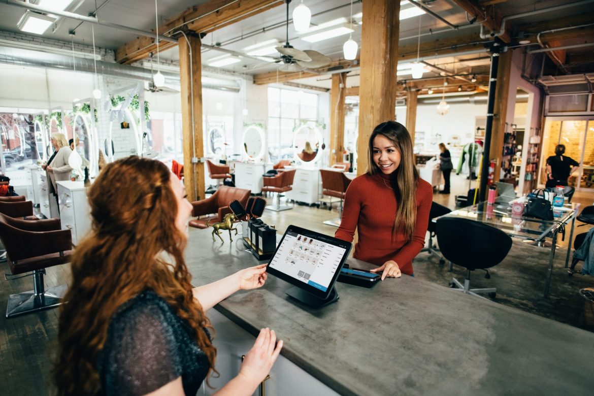 Stablecoin: two women at a table chatting over their laptops