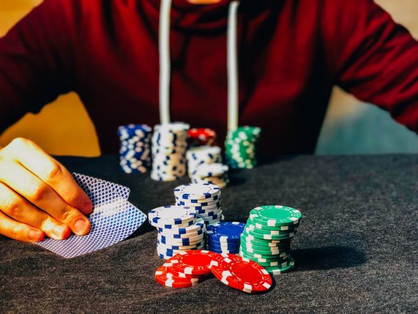 Financing risks: man at casino, chips on table and he is looking at his cards