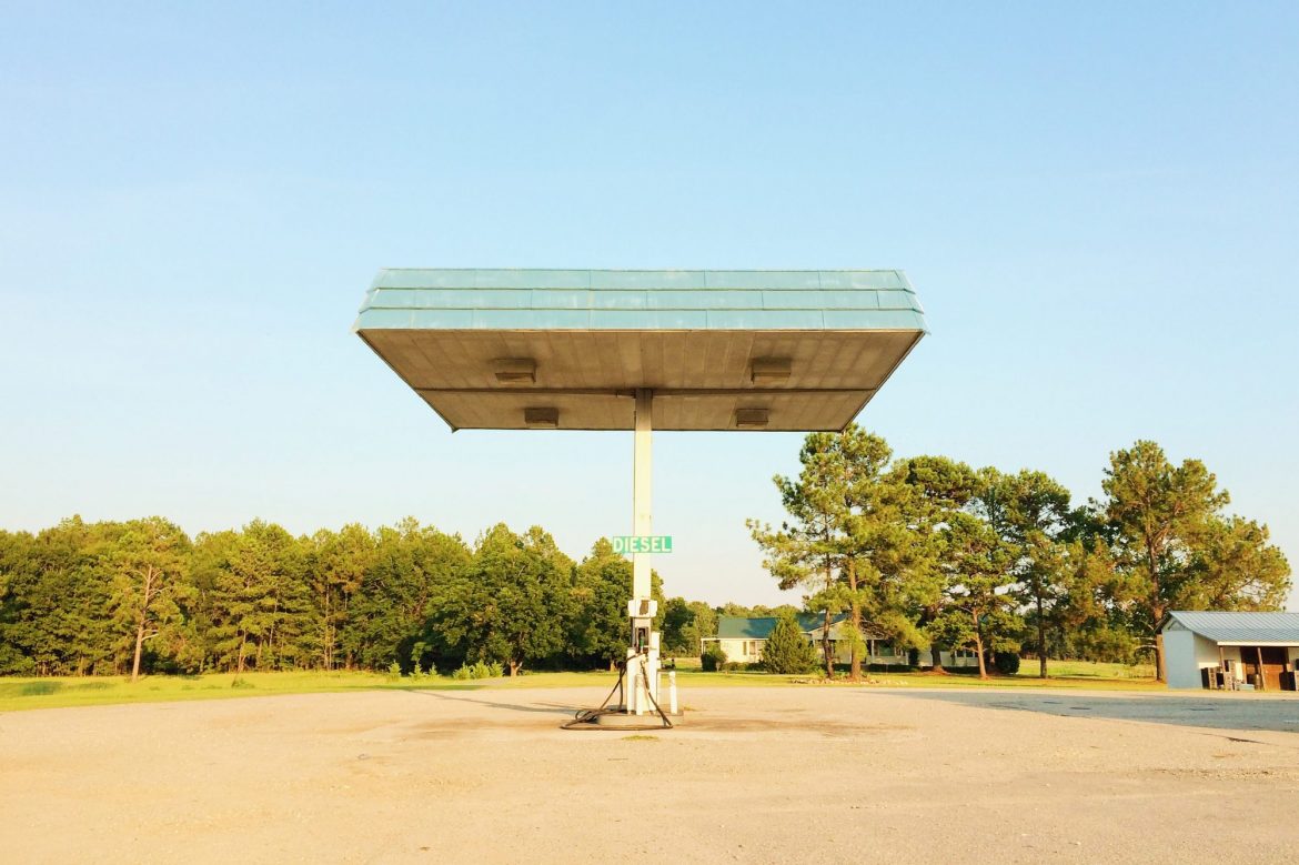 Uses of oil: Empty, abandoned gas station surrounded by trees