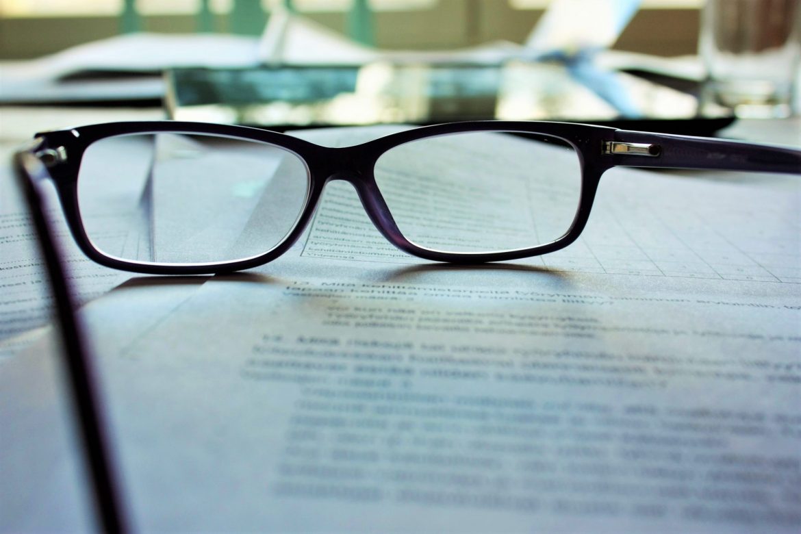 Convertible bonds: Close up image of reading glasses resting on the page of an open book