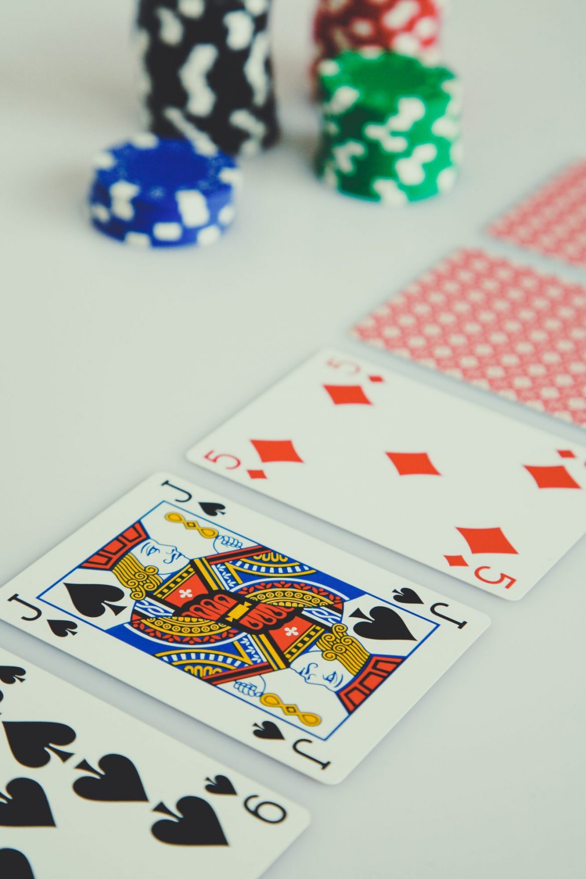 Investment scammers: Playing cards and casino chips on a white table
