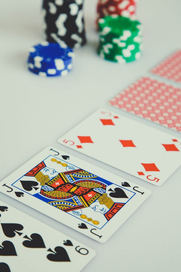 Investment scammers: Playing cards and casino chips on a white table