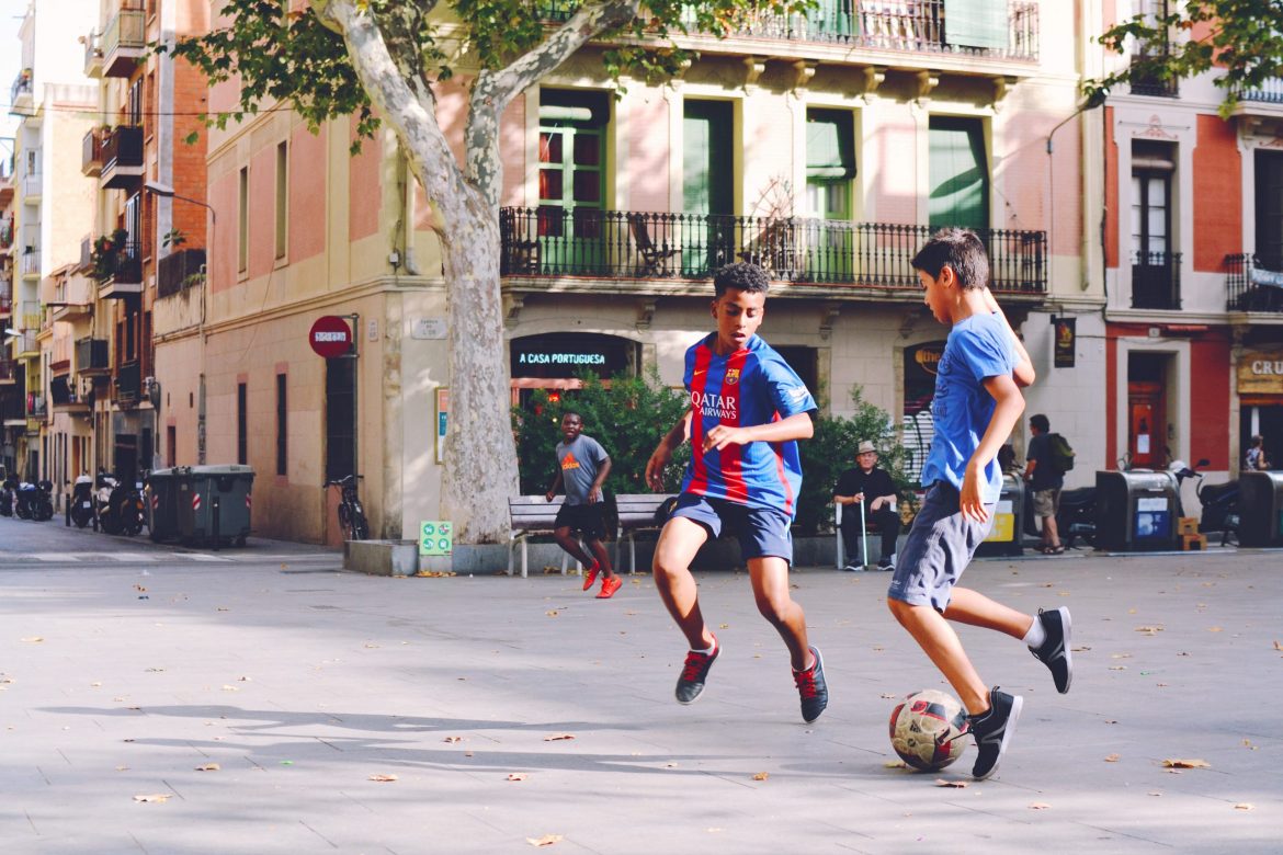 Football memorabilia Three young boys playing football in the square of a charming European city