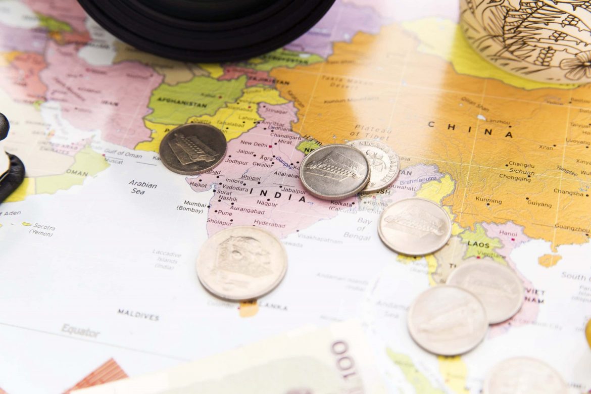 Initial coin offering: Investing in an ICO: a number of coins scattered across a map of the world