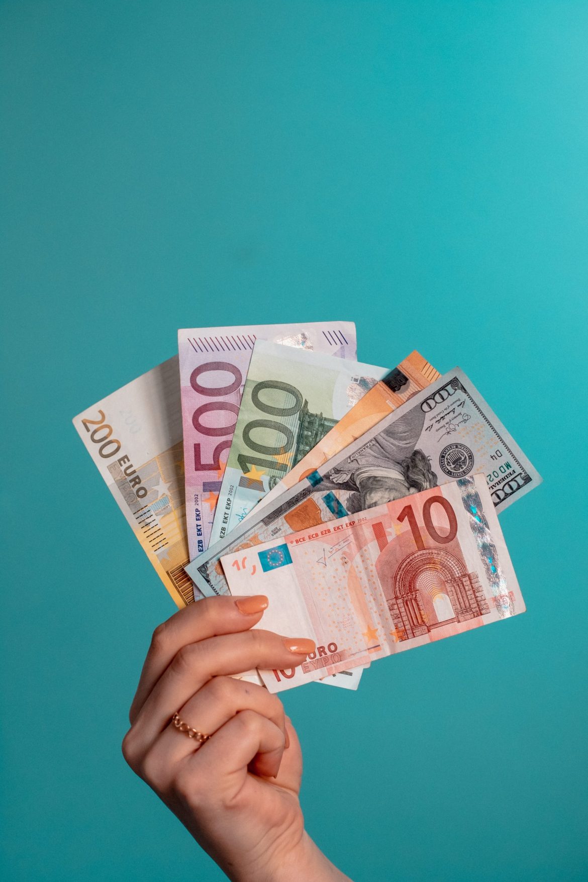 Forex trading scams: A range of different currency banknotes held up to the camera