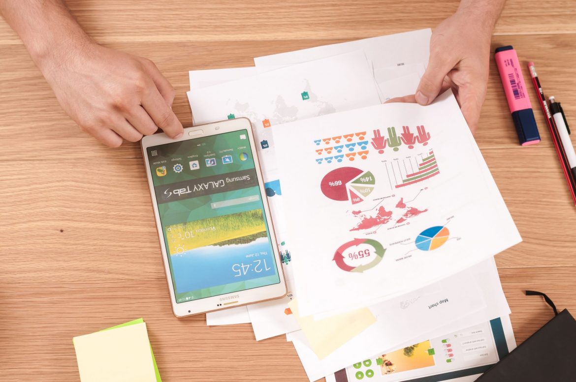 Serious Fraud Office: Person sitting at a desk with a smartphone and reviewing pages from a presentation