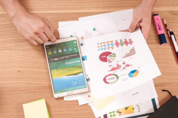 Serious Fraud Office: Person sitting at a desk with a smartphone and reviewing pages from a presentation