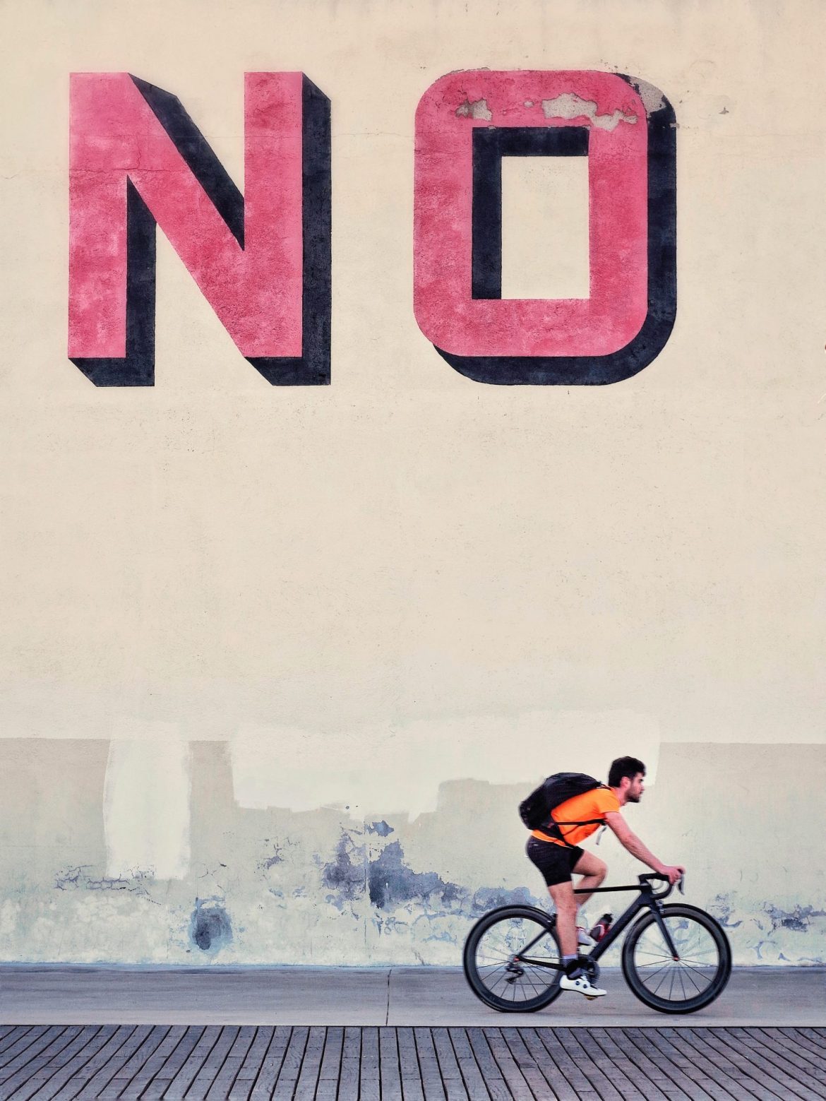 Boiler room frauds: Man riding a bike past a sign that says NO